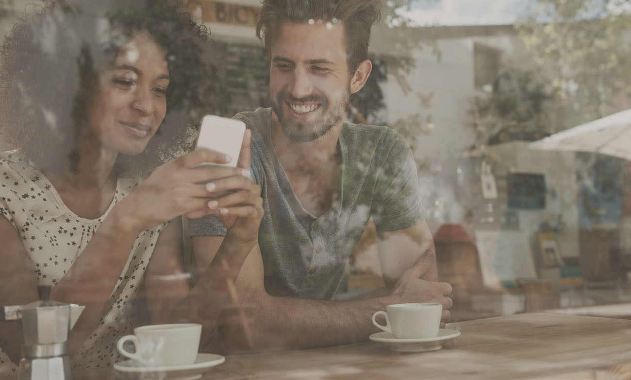 couple at coffee shop using smartphone 